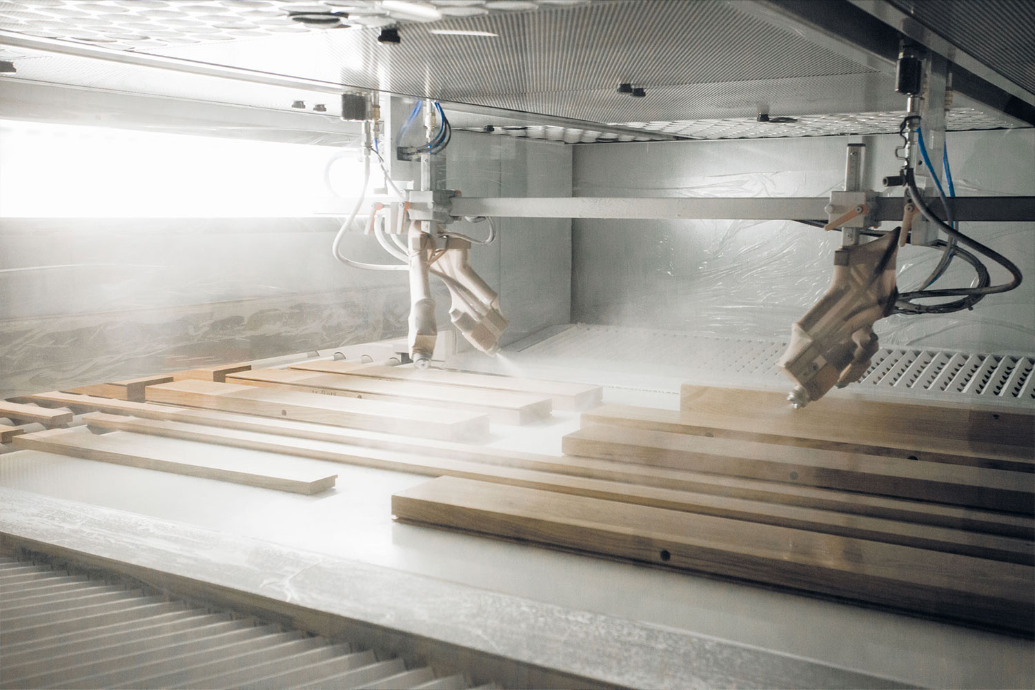 View into the spray booth. Equipped with one paint supply line each for UV clear coatings, UV color coatings, and for stains.