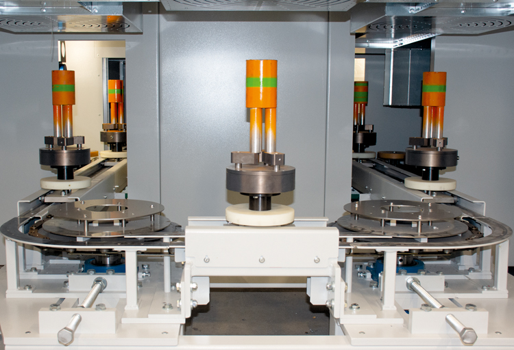 View of the spindle chain conveyor system in the painting booth for the rotationally symmetrical inner coating of the pipe coupling threads.